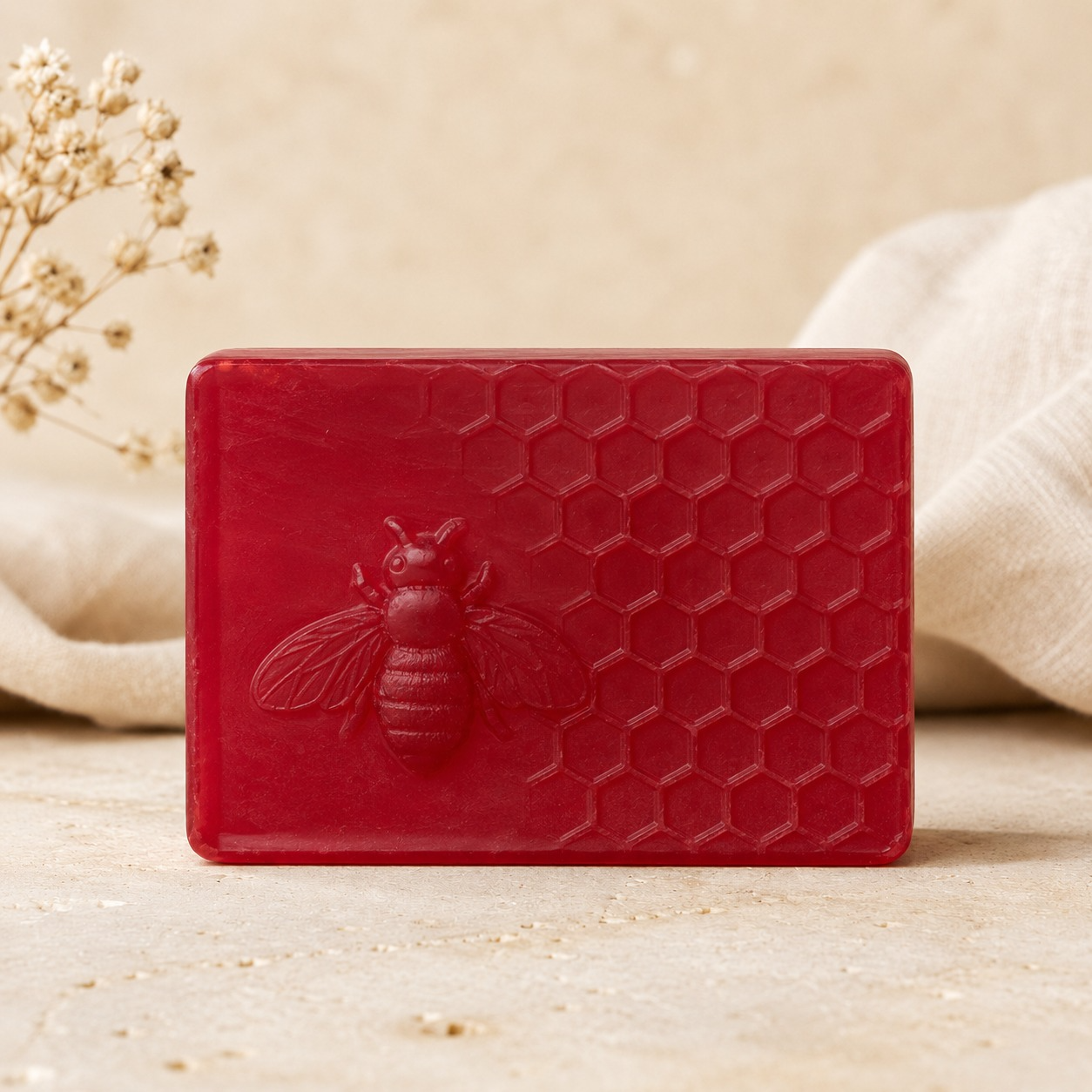 Jabón artesanal rojo con abeja y textura de panal de Los Aromas de Rafa